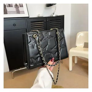Détail du sac bandoulière en cuir noir matelassé avec motif étoile et chaîne dorée