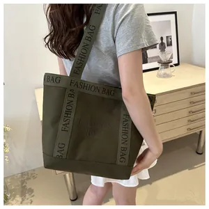 Vue détaillée de dos d'un sac cabas en toile vert foncé avec des sangles lettrées