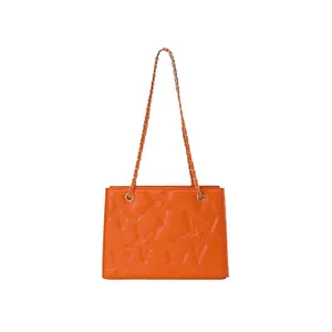 Sac à bandoulière orange avec motif d'étoile matelassé et chaîne dorée