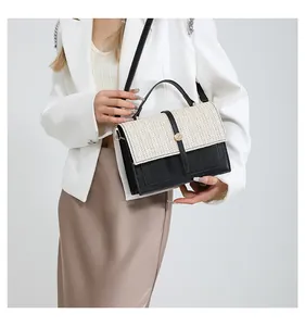 Detail of contrast stitch patchwork bag with straw woven flap and golden metal lock