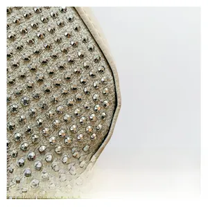 Close-up of beige woven fabric with silver rhinestones and premium piping detail