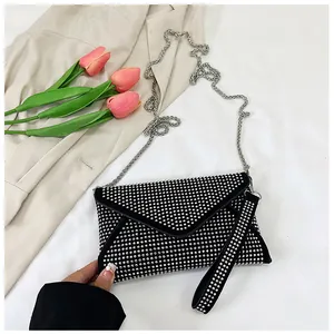 Detail of black rhinestone envelope bag with silver studs and metal chain strap