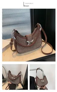 Detail view of brown hobo bag featuring silver studs and a metallic bow accent