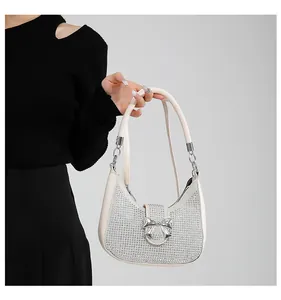 Detail of white sparkling rhinestone hobo bag with a silver metallic bow decoration