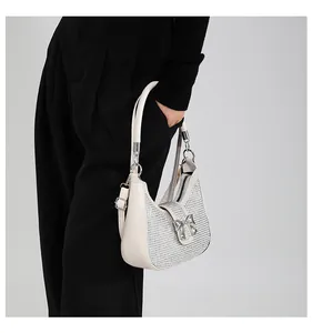 Detail of silver rhinestone half-moon bag with metallic bow and adjustable strap