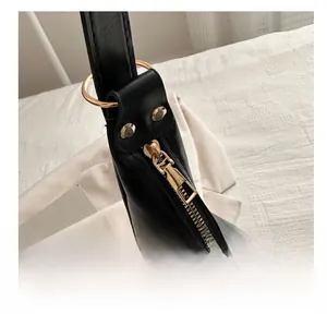 Detailansicht des glatten goldenen Reißverschlusses der schwarzen Leder-Tasche