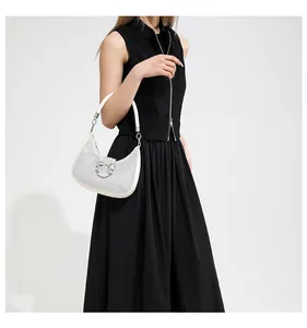 Detail of a sparkling rhinestone hobo bag with a silver metal bow on black dress