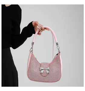 Detail of pink hobo bag featuring sparkling rhinestones and a silver metallic bow accent