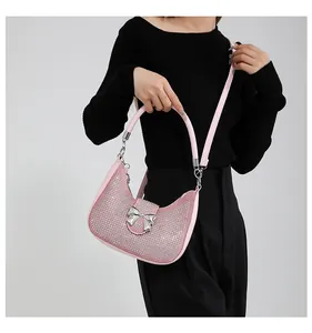 Pink underarm bag featuring silver rhinestones and a large metal bow detail
