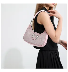Detailed shot of pink rhinestone hobo bag with metallic bow buckle on shoulder