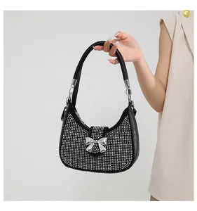 Detailed close-up of a black rhinestone shoulder bag featuring a silver bow metal buckle