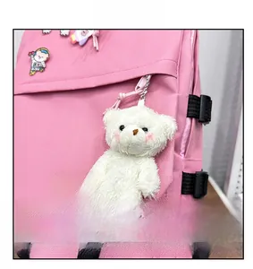 Gros plan détaillé du sac à dos rose avec ours en peluche blanc et badges décoratifs