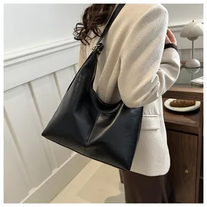 Detail of the black PU leather shoulder bag with gold metal buckle and zipper closure