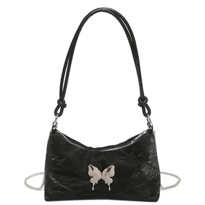 Sac bandoulière noir avec breloque papillon argentée et bandoulière en chaîne