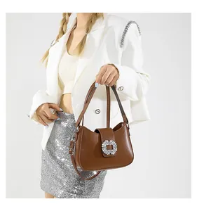 Detail of vintage brown leather handbag featuring a sparkling square crystal buckle