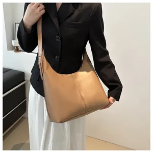 Detailed view of khaki leather hobo bag featuring contrast stitching and adjustable strap