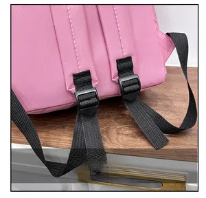 Détail de la bandoulière de sac à dos rose avec boucle de réglage en plastique noir robuste