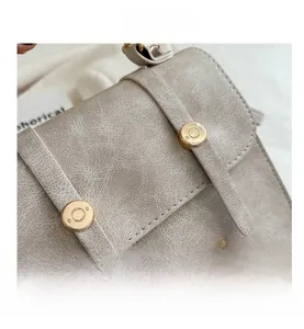 Detailed close-up of beige cracked texture leather with golden butterfly embroidery