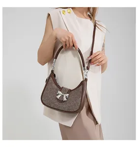 Detail of brown shoulder bag with sparkling silver rhinestones and a metal bow buckle