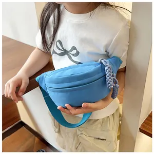 Détail du sac bandoulière enfant bleu clair avec pendentif tissé et sangle ajustable