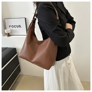 Macro detail of caramel brown leather hobo bag showing texture and adjustable metal buckle