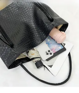 Close-up of a black woven tote bag showing spacious interior for daily essentials