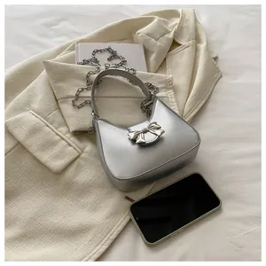 Détail du sac demi-lune argenté avec nœud 3D et bandoulière en chaîne métal