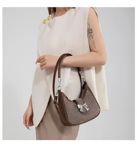 Brown semi-circle underarm bag featuring sparkling rhinestones and a silver bow detail