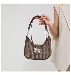 Detail of brown hobo bag with silver rhinestones and a metal bow accent