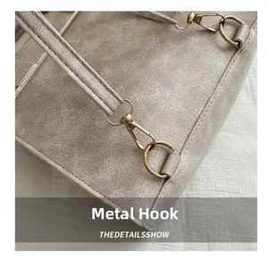 Detailed close-up of golden hardware hooks on a vintage texture faux leather backpack