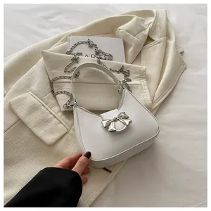 Détail du sac à main crème en similicuir avec boucle nœud argenté et bandoulière chaîne