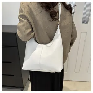 Chic white leather hobo shoulder bag styled with a professional suit for workplace fashion