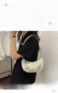 Detail of beige saddle bag with glossy PU leather, silver buckles and punk style details
