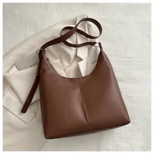 Detailed view of dark brown leather tote bag with vertical stitching and wide strap