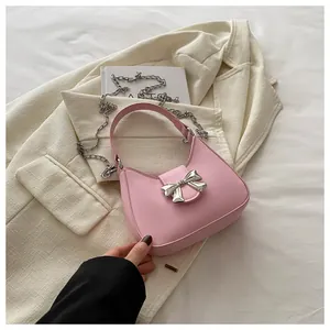 Détail du sac Hobo en cuir PU rose avec nœud en métal argenté et bandoulière amovible