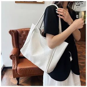Close-up of the large white woven tote bag showing detailed texture and handle