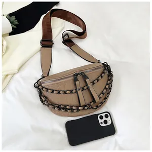 Detail of khaki crescent chest bag with crocodile pattern leather and double black chains
