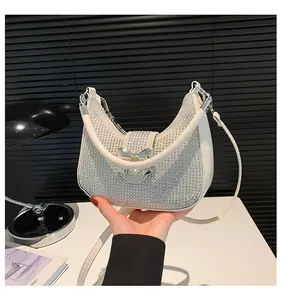 Detail of white rhinestone crescent bag with metallic bow buckle and adjustable strap