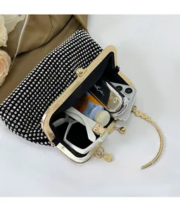 Detail view of black rhinestone handbag interior capacity with metal ring handle