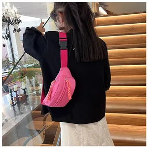 Vue de dos d'un enfant portant un sac bandoulière en nylon rose vif avec sangle