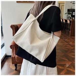Close-up of white woven tote bag with fine grid texture and long shoulder straps