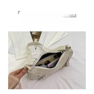 Spacious interior of beige half-moon saddle bag showing storage for phone and mirror