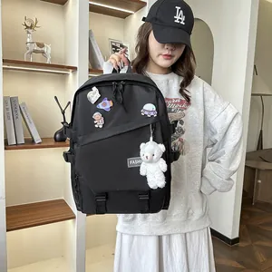Gros plan d'un sac à dos noir avec des badges d'astronaute et un pendentif ours en peluche