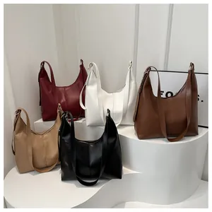 Minimalist faux leather tote bags in five colors displayed on a curved white pedestal