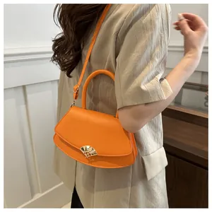 Détail du sac à bandoulière en cuir orange vif avec un élégant fermoir éventail doré