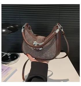 Detail of coffee brown hobo bag with silver crystal rhinestones and metal bow accent