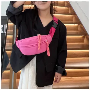 Détail d'un sac bandoulière enfant rose fuchsia avec tirettes de zip tissées et sangle