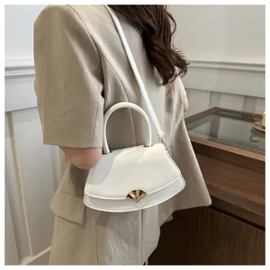 Détail d'un sac à bandoulière blanc demi-rond doté d'un fermoir doré en forme d'éventail