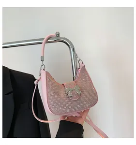 Close-up of pink rhinestone underarm bag with a silver bow clasp and adjustable strap