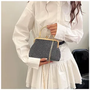 Detail of vintage black rhinestone evening bag with gold metal handle and chain